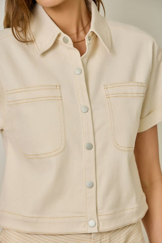Beige sleeveless shirt with button details on a neutral background